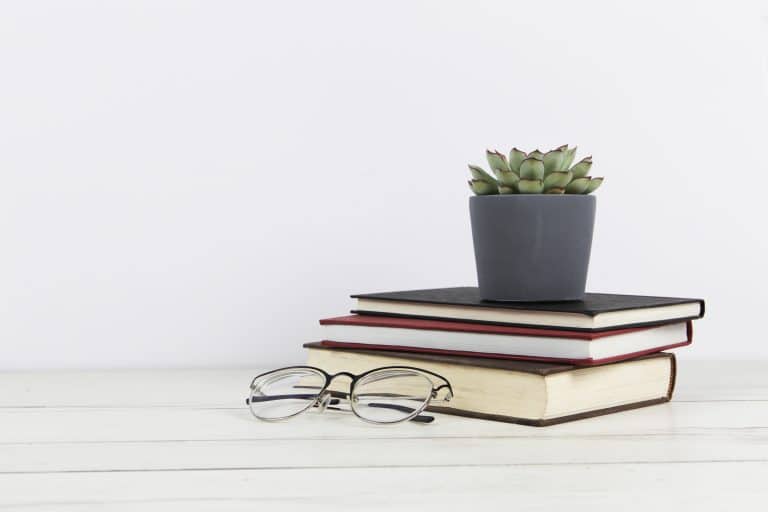 Books stack with glasses and a cup of tea